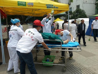 蒙牛志愿者協(xié)助醫(yī)護(hù)人員將傷者從救護(hù)車運送至醫(yī)院